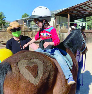 Kathy‘s endurance Mustang, Timber, serving as a therapy horse.